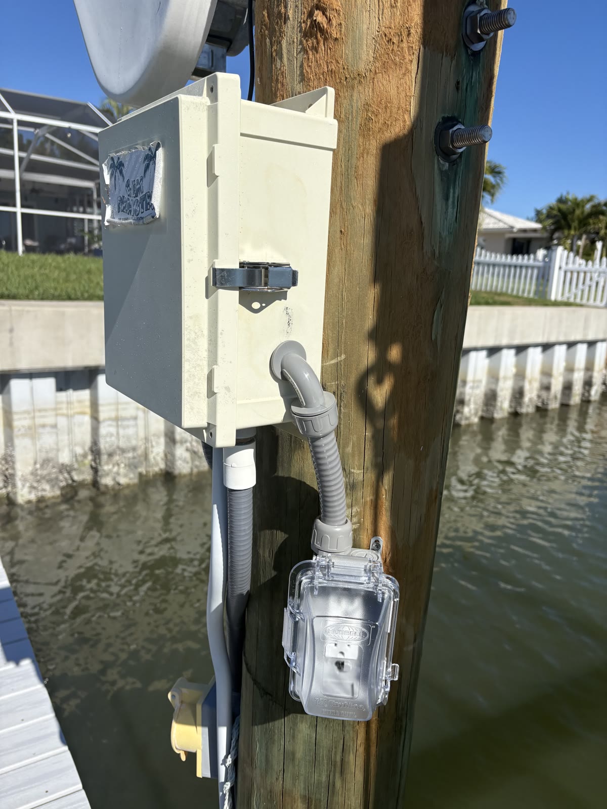 Dock electrical disconnect and meter mounted on a piling over the water in Tampa Bay