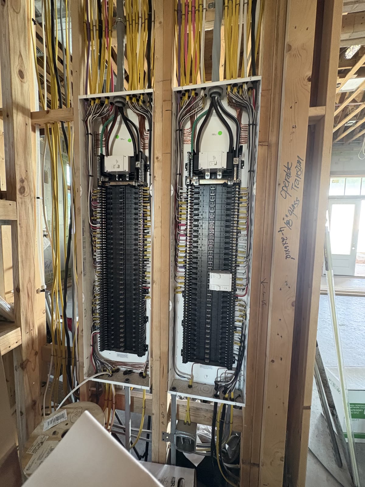 Twin residential electrical panels with neatly bundled circuit wiring installed by Brightwire Electric