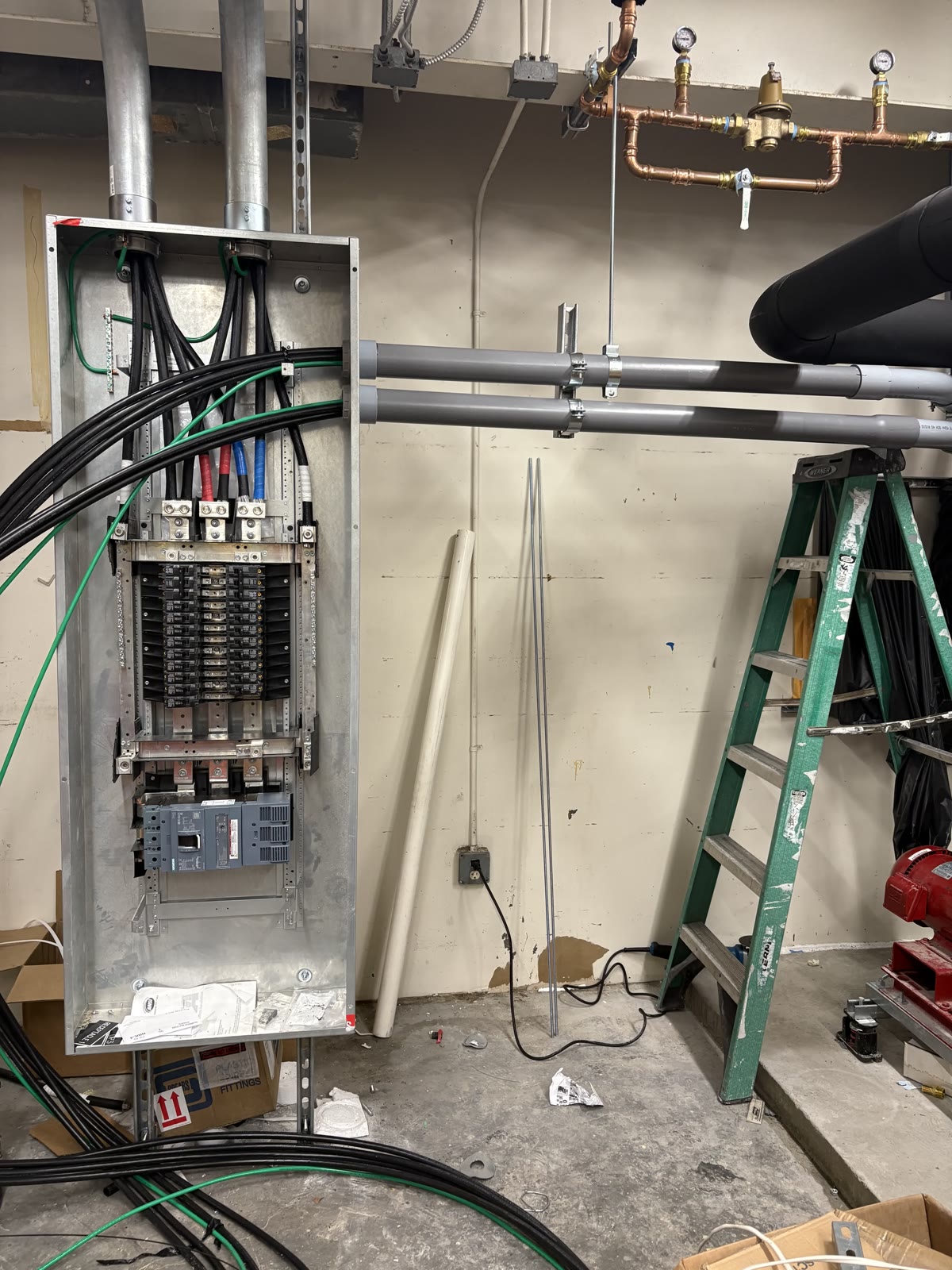 Open commercial panelboard and conduit in a mechanical room