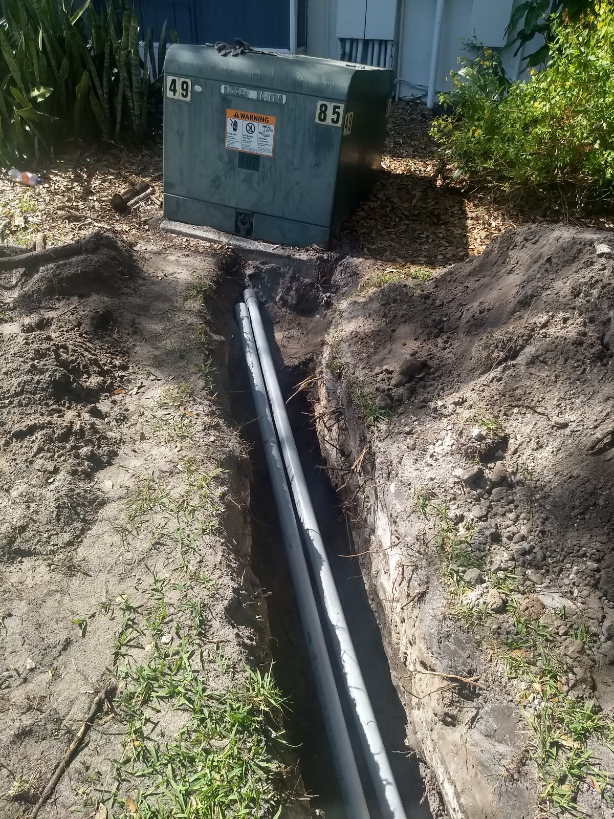 Underground service conduit run to a pad-mounted transformer