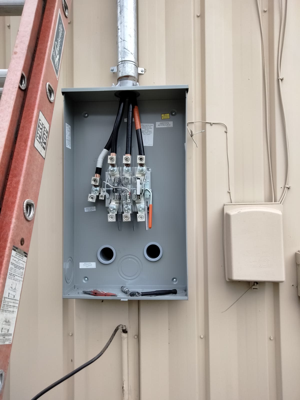 Open meter cabinet with service conductors landed during a Brightwire Electric service upgrade