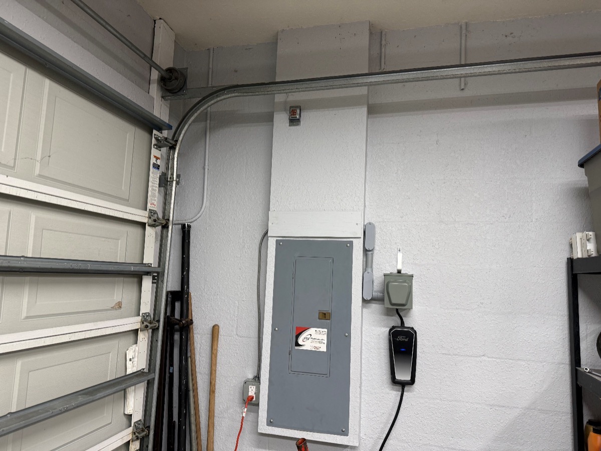Electrical panel and EV charger setup in residential garage by Brightwire Electric
