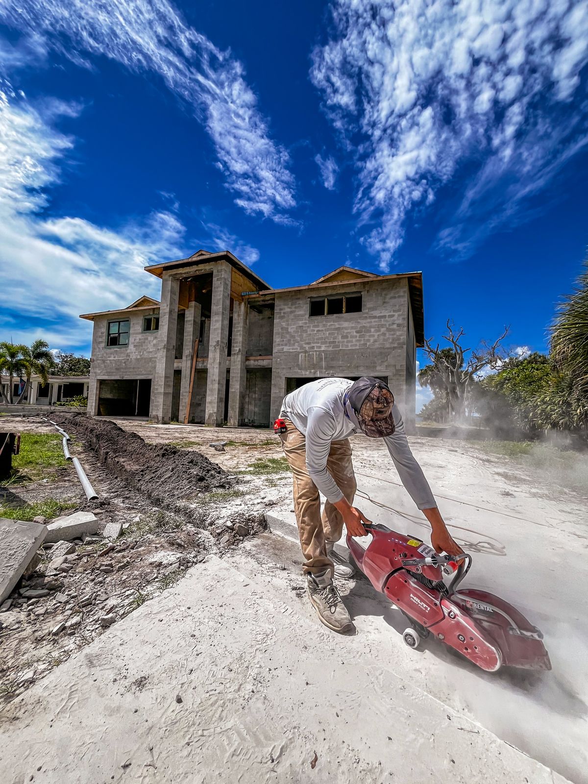 Brightwire Electric electrician cutting concrete for underground conduit at a new home build